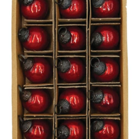Box of red glass ornaments with black bases on a white background