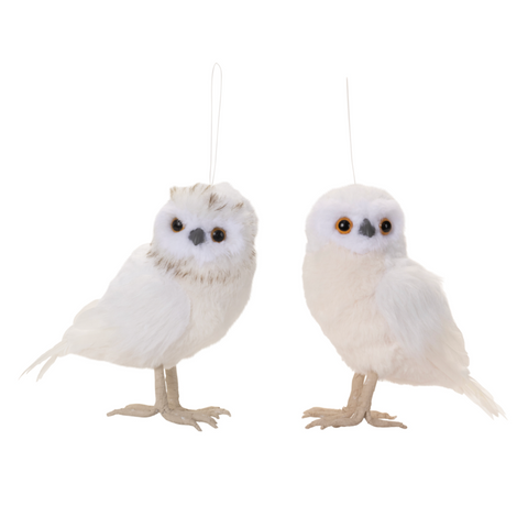 Two white owl ornaments hanging against a white background