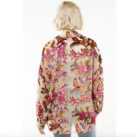 Person wearing a floral patterned shirt on a white background