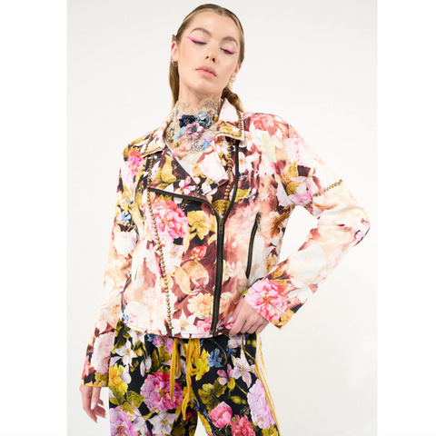 Woman wearing a colorful floral jacket and pants on a white background