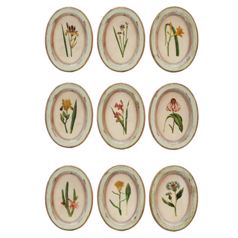 Set of nine oval plates with floral designs on a white background