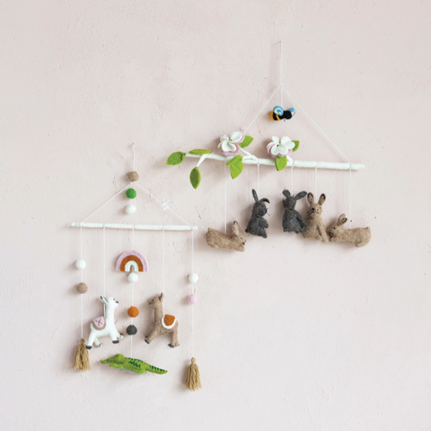 Children's mobile with animal figurines and decorative elements on a plain background