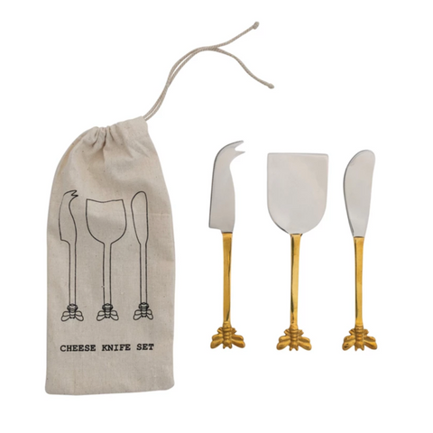 Set of three cheese knives with gold handles and a drawstring bag labeled 'Cheese Knife Set' on a white background.