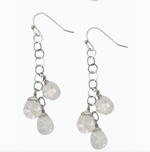 Silver earrings with clear teardrop-shaped stones on a white background