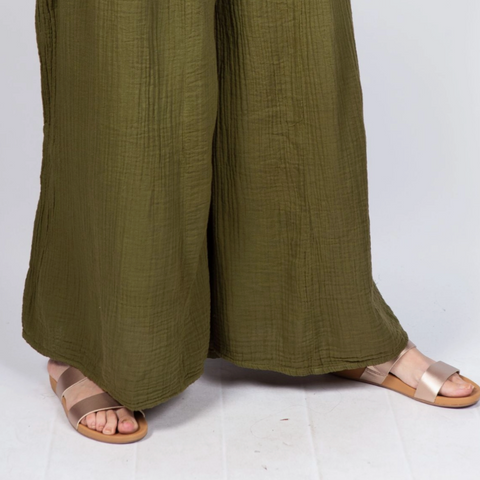 Green wide-leg pants worn by a person on a white background