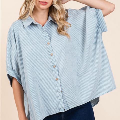 Woman wearing a blue and white striped shirt with a beige background