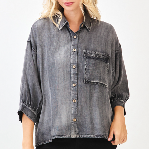 Woman wearing a gray denim shirt on a white background
