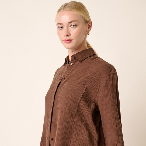 Woman wearing a brown shirt against a beige background