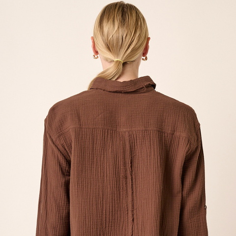 Brown corduroy shirt worn by a person on a beige background