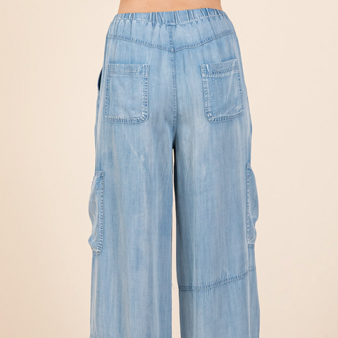 Light blue denim wide-leg pants on a beige background