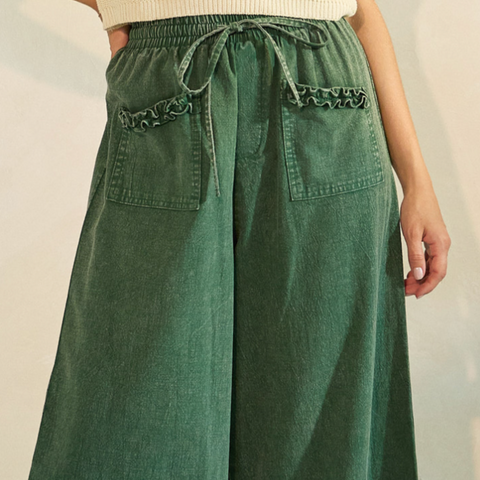 Green wide-leg pants with lace details on a plain background
