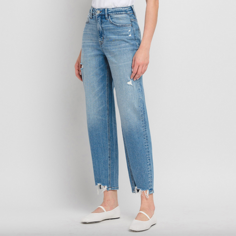 Person wearing light blue jeans on a plain background