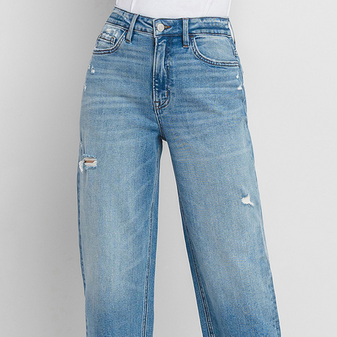 Light blue jeans with slight distressing on a gray background