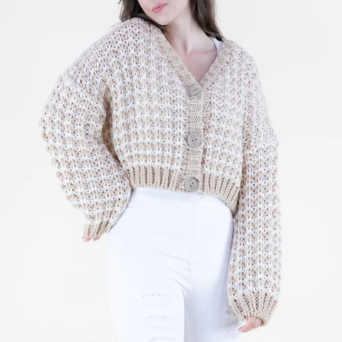 Woman wearing a beige knitted cardigan on a white background