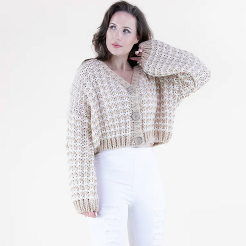 Woman wearing a beige knitted cardigan on a white background