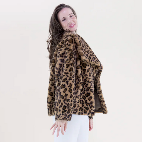 Woman wearing a leopard print coat against a plain background