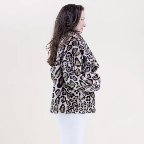 Person wearing a leopard print jacket on a plain background