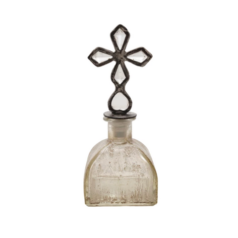 Decorative bottle with a cross-shaped top on a white background