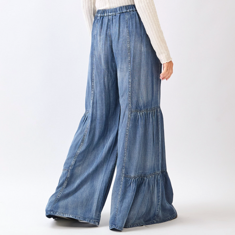 Wide-leg denim pants worn by a person on a white background