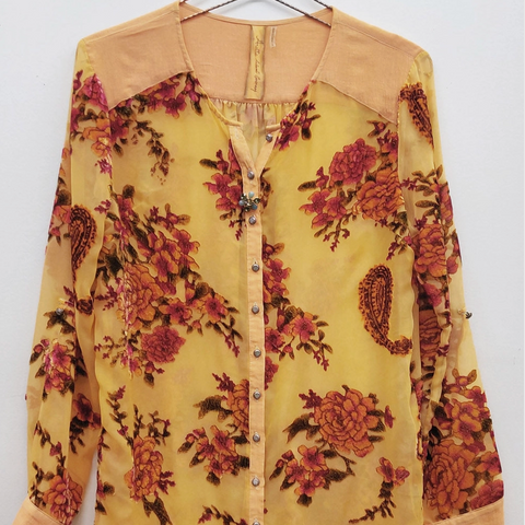 Yellow floral dress on a hanger against a white background