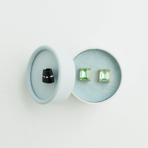 Pair of earrings with gemstones displayed on a white background