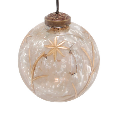 A clear glass Christmas ornament with gold glittery star and leaf designs, hanging from a gold string with a bronze-colored cap, shown against a plain white background.