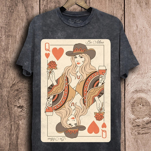 Black t-shirt with a graphic design of a woman in a hat and hearts on a wooden background